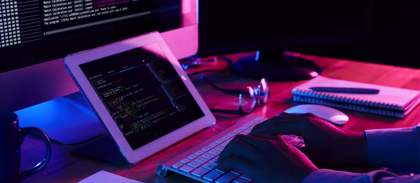 Web developer coding a custom website across desktop and tablet screens
